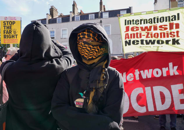 An anti Zionist protester stands in front of banners at Cable Street on October 4, 2026 in London, England on the 90th anniversary of the Battle of Cable Street.