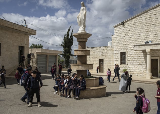 Students walk through the school of the "Our Lady of Visitation" Catholic church in the Palestinian town of Zababdeh in the northern West Bank, on April 10, 2025. 