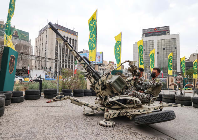 Iranians in camouflage outfits demonstrate the use of a double-barrel anti-aircraft gun during the inauguration of a training centre by the Iranian army for "Jan-Fadayan" (those willing to sacrifice their lives) volunteers, at Haft-e-Tir Square in central Tehran on October 3, 2026.