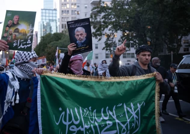 Pro-Palestinian protesters hold a Hamas flag and a photo of Yahya Sinwar, the mastermind of the Oct. 7, 2023, attack as they march toward Union Square.