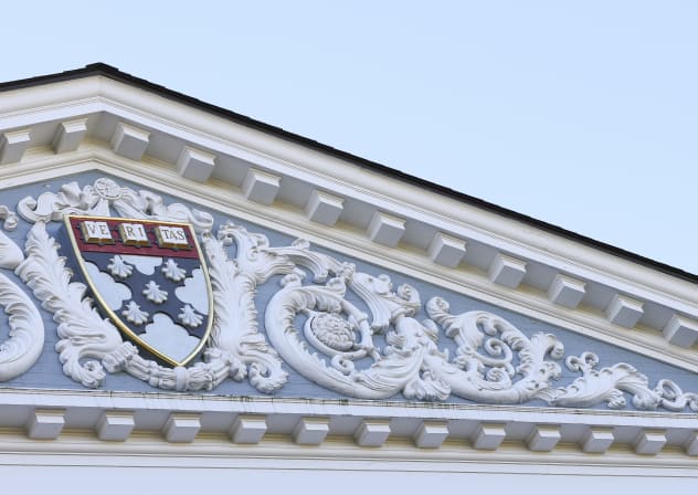 The Harvard University Coat of arms (Ve Ri Tas) is displayed on the front of the Harvard Business School building on October 25, 2025 in Boston, Massachusetts. 
