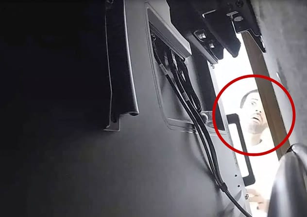 A man described as Abdulrahman Alfozan, a Saudi national employed as an OpenAI engineer, looks behind a television where a recording device had been placed at a conference room in OpenAI offices, in a still image from surveillance video included in a charging document. October 5, 2026.