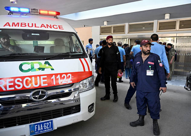 Security personnel stand next to an ambulance following a fire incident outside the Mother and Child Health (MCH) ward at the Pakistan Institute of Medical Sciences (PIMS) Hospital in Islamabad on August 26, 2026. 