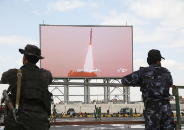 Yemeni security soldiers stand in front of a screen broadcasting Houthi-run forces launching a missile, during a demonstration staged to support missile forces in protecting the country's sovereignty and to denounce the Saudi accusation that Yemenis are attempting to attack Maca, on September 18.