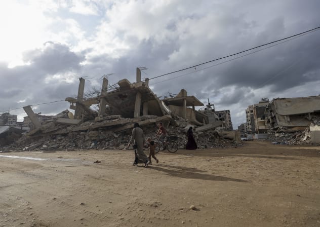 Gazans walk past damaged buildings in Gaza City, Gaza Strip on October 18, 2026; Illustrative.