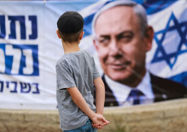A child looks at a banner depicting Prime Minister and Likud party leader Benjamin Netanyahu, during the country's national elections in Jerusalem, October 27, 2026.