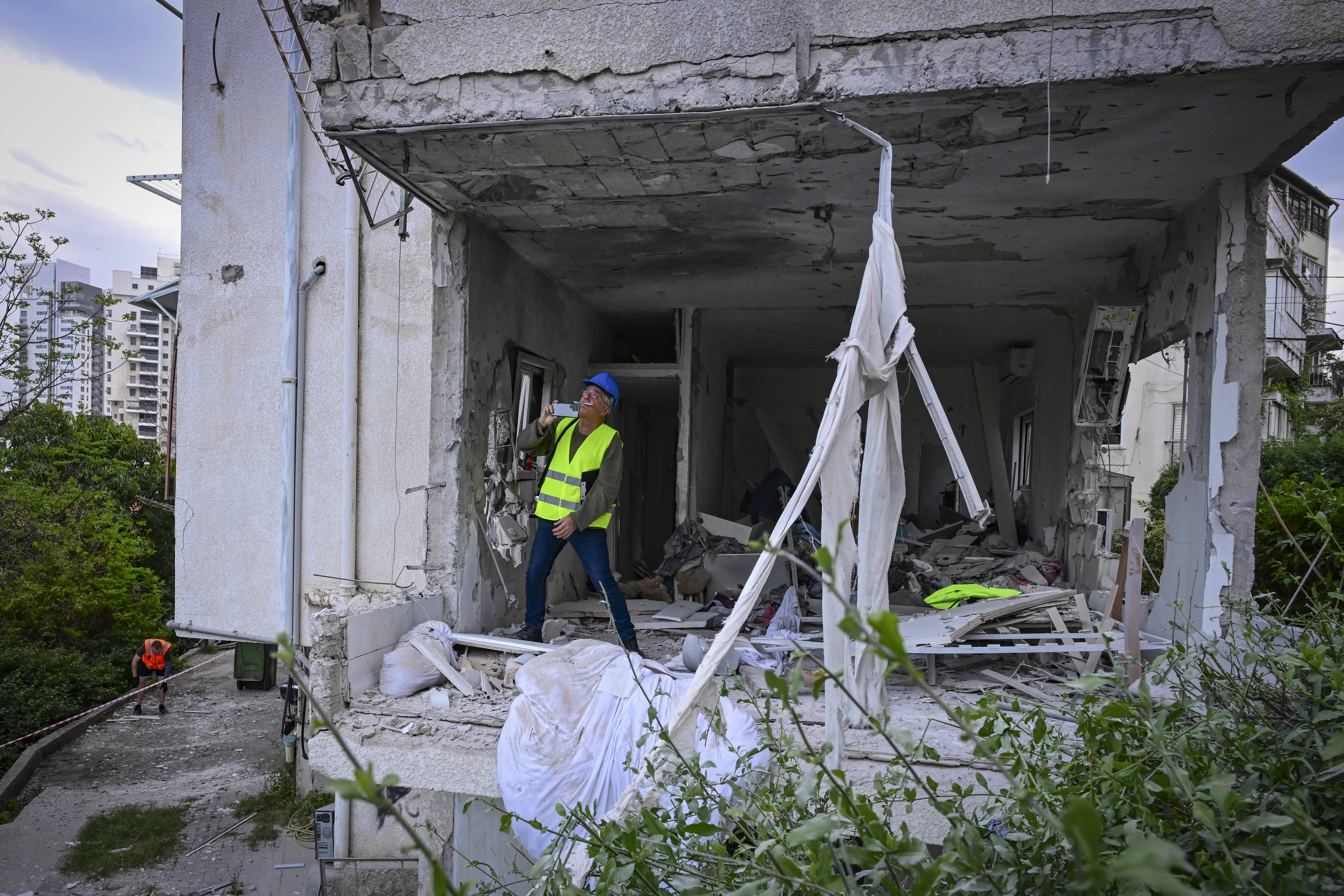 Israeli security and rescue forces at the scene where a missile fired from Iran toward Israel caused damage in Ramat Gan, March 18, 2026. (photo credit: AVSHALOM SASSONI/FLASH90)