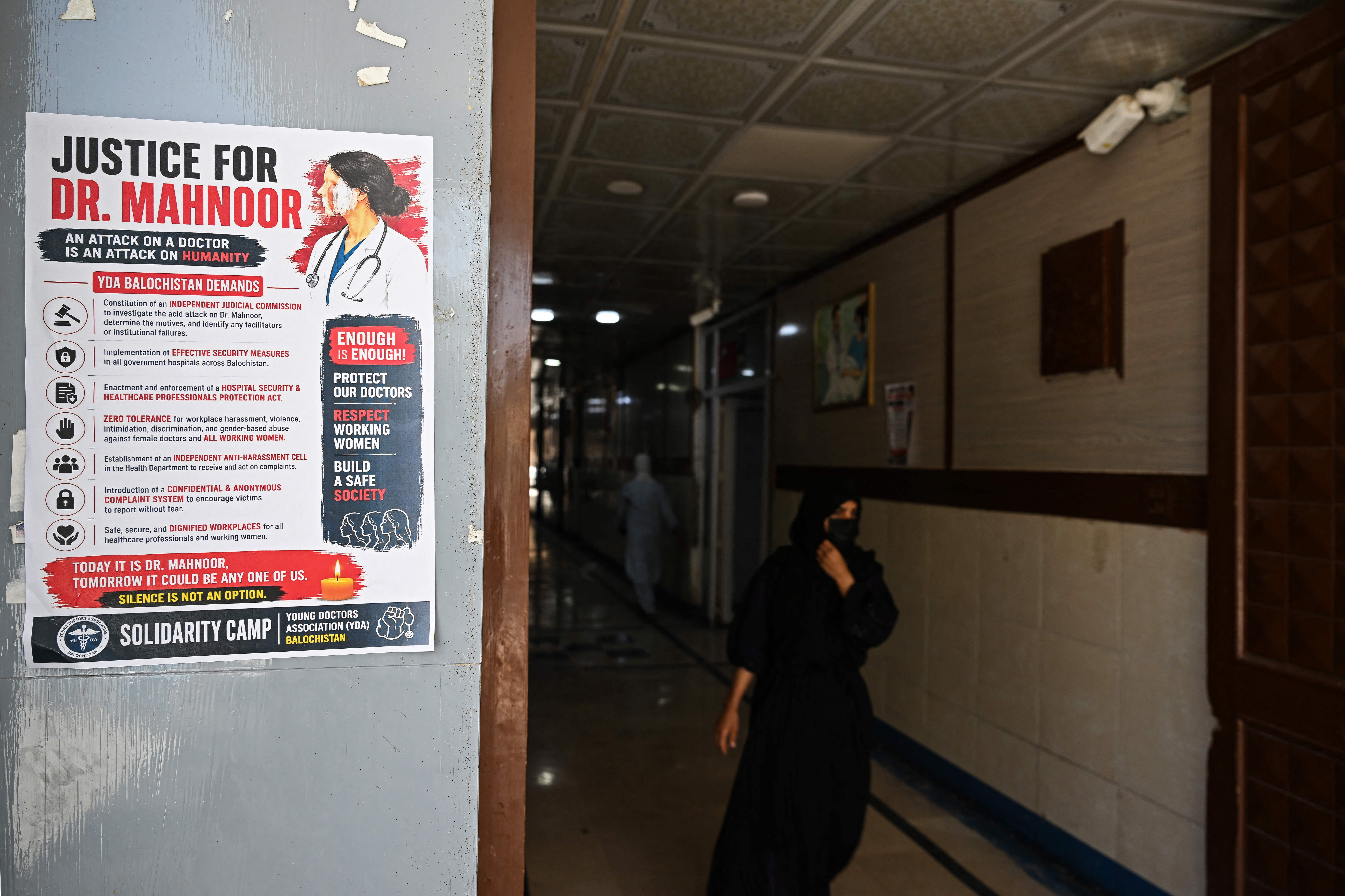 A woman walks past a poster displayed by medical practitioners to express solidarity with acid attack victim doctor Mahnoor Nasir, at a hospital in Quetta on June 9, 2026. (photo credit: Banaras KHAN / AFP via Getty Images)