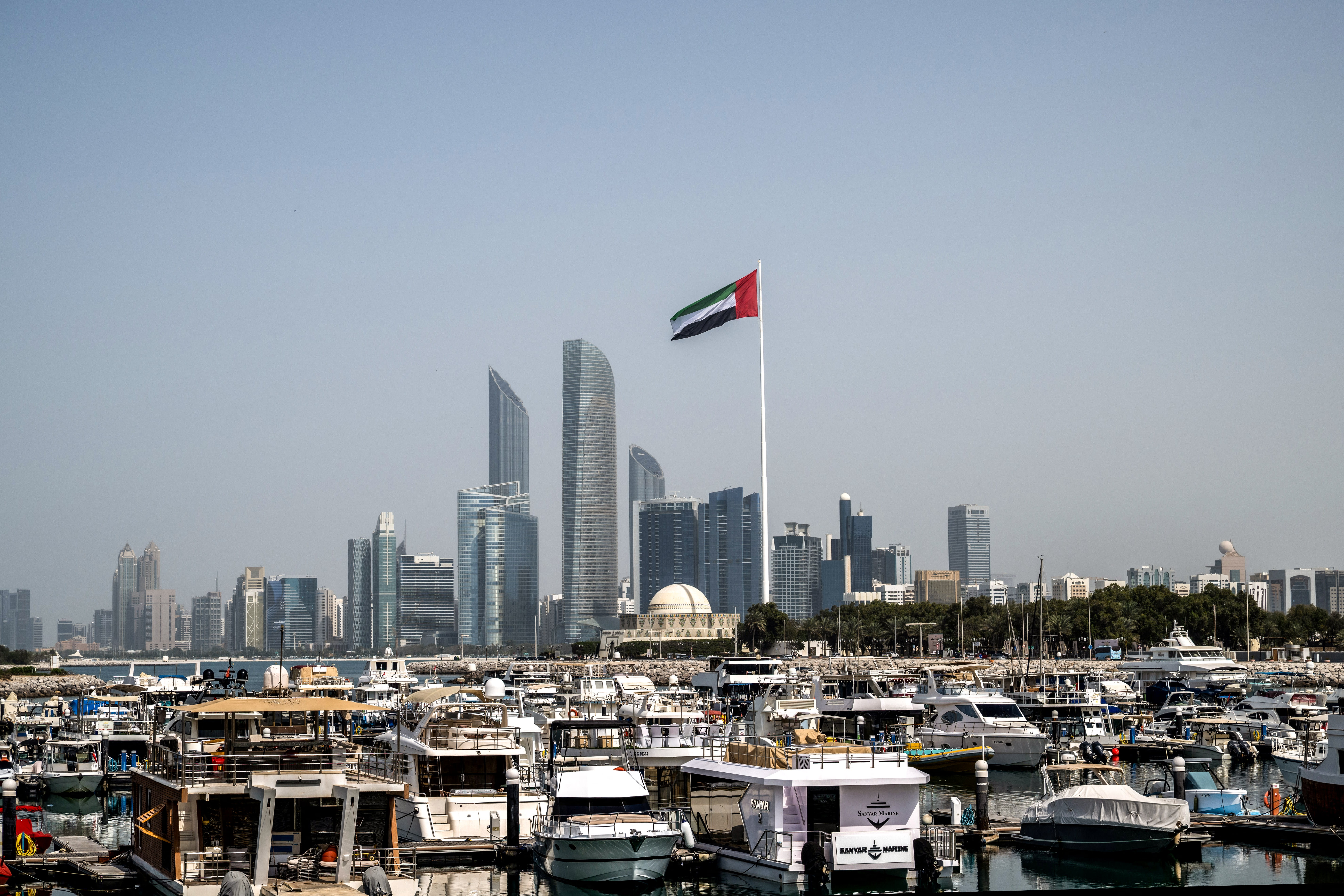 The United Arab Emirates flag flutters against the backdrop of the Abu Dhabi Skyline following a reported Iranian strike on March 1, 2026. (photo credit: Ryan Lim / AFP via Getty Images)