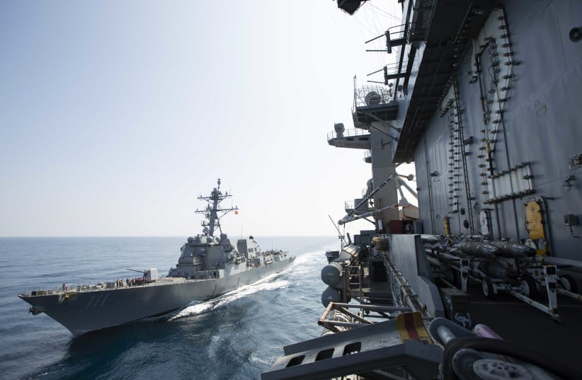 The Nimitz-class aircraft carrier USS Abraham Lincoln (CVN 72) sails alongside the Arleigh Burke-class guided-missile destroyer USS Spruance (DDG 111) in the U.S. 5th Fleet area of operations.