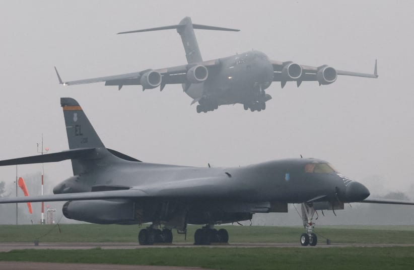 A United States Air Force (USAF) Boeing C-17A Globemaster comes in to land behind a USAF B-1B bomber parked beside the runway at RAF Fairford airbase, in Fairford, Britain, March 8, 2026.