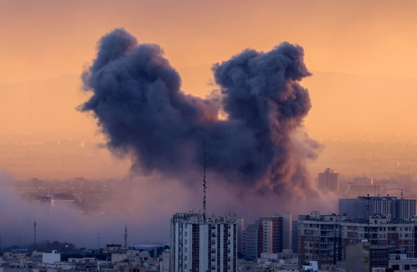 A plume of smoke rises after a strike on the Iranian capital Tehran, on March 3, 2026. (photo credit: ATTA KENARE / AFP via Getty Images)