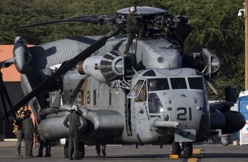A US Marine Corps crew works on a CH-53E Super Stallion helicopter on the tarmac at Mercedita Airport in Ponce, Puerto Rico, on January 15, 2026.