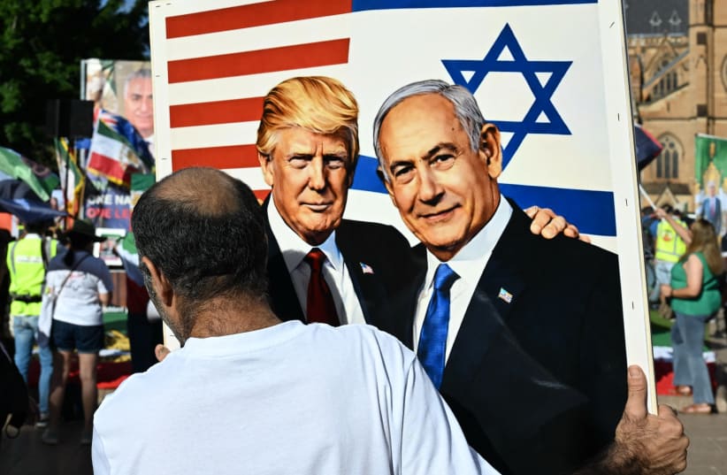 A member of the Iranian community in Australia holds a placard in support of US President Donald Trump and Israeli Prime Minister Benjamin Netanyahu during a rally following US and Israeli attacks on Iran sparking the Middle East war, in Sydney on March 14, 2026.