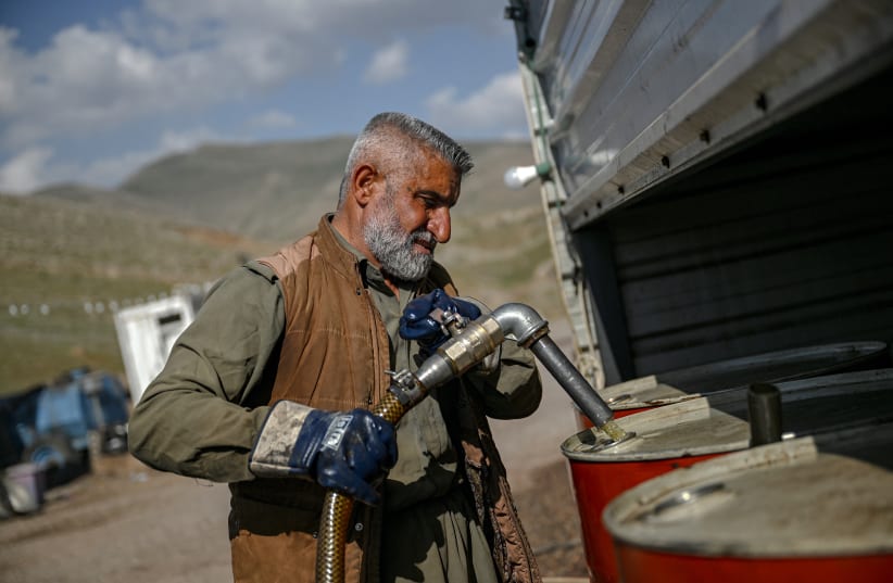 A vendor pumps petrol from Iranian fuel oil tankers for resale near the Bashmagh border crossing on March 11, 2026. 