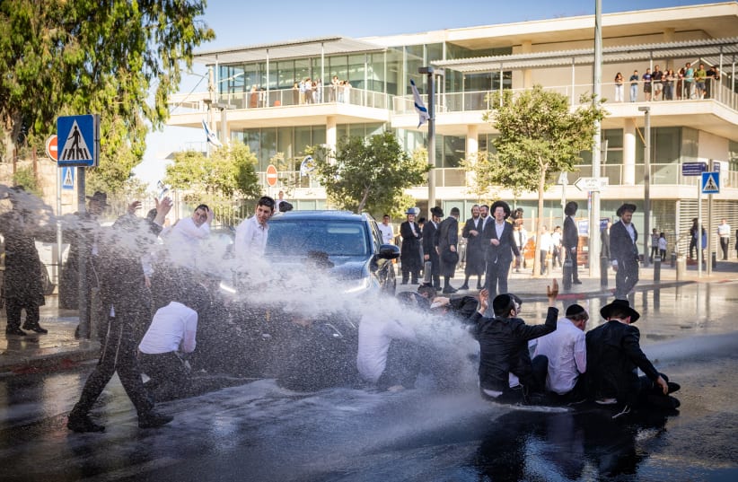 Israel Police officers spray water jets at haredi (ultra-Orthodox) protesters blocking the road outside Supreme Court Justice Noam Sohlberg's residence in Jerusalem, June 10, 2026; illustrative.