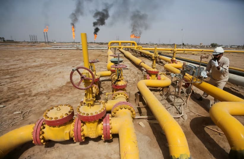 A worker checks an oil pipeline at Nahr Bin Umar oil field, north of Basra, Iraq March 22, 2022.