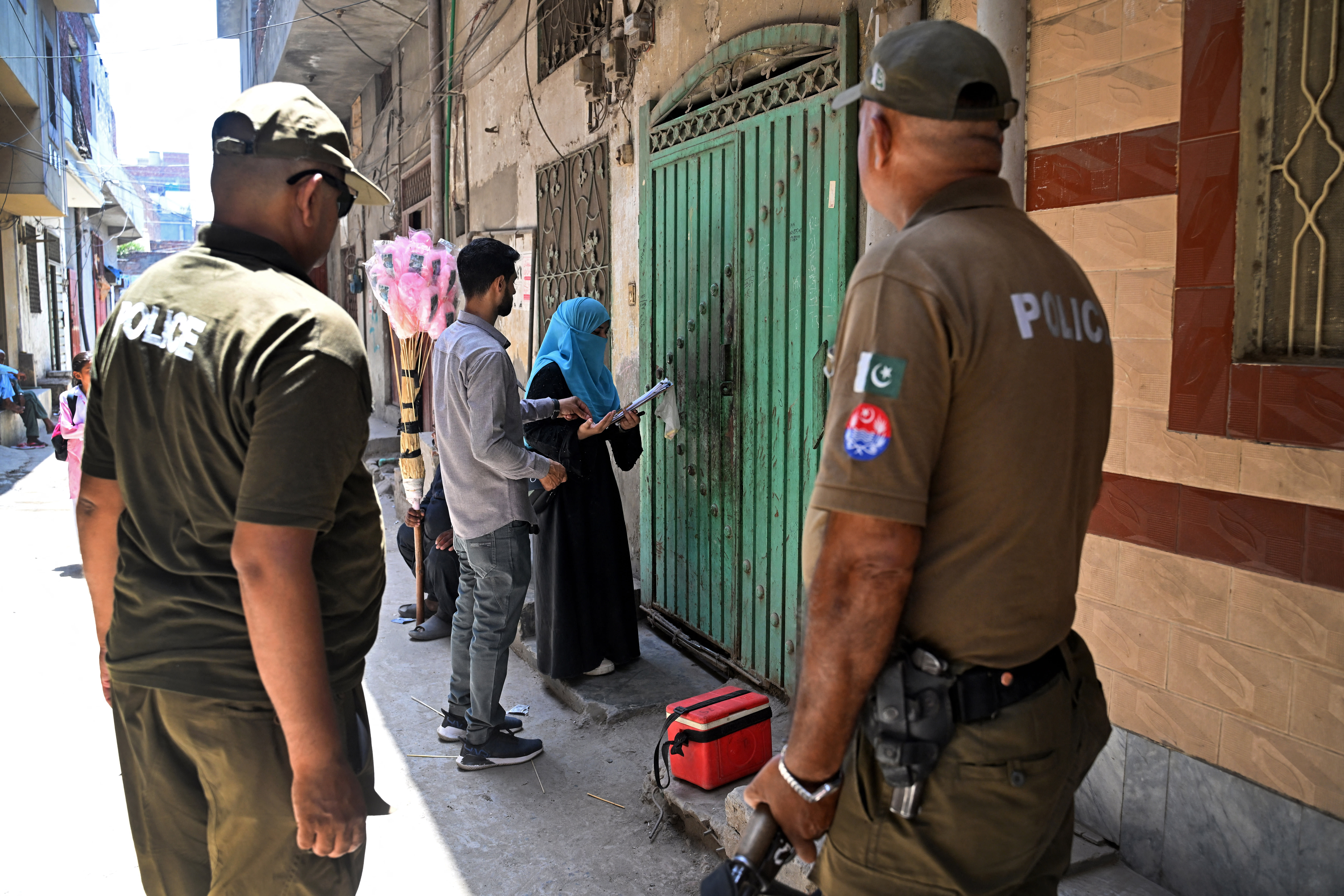 Pakistani police escort an aid worker. (photo credit: ARIF ALI/AFP via Getty Images)