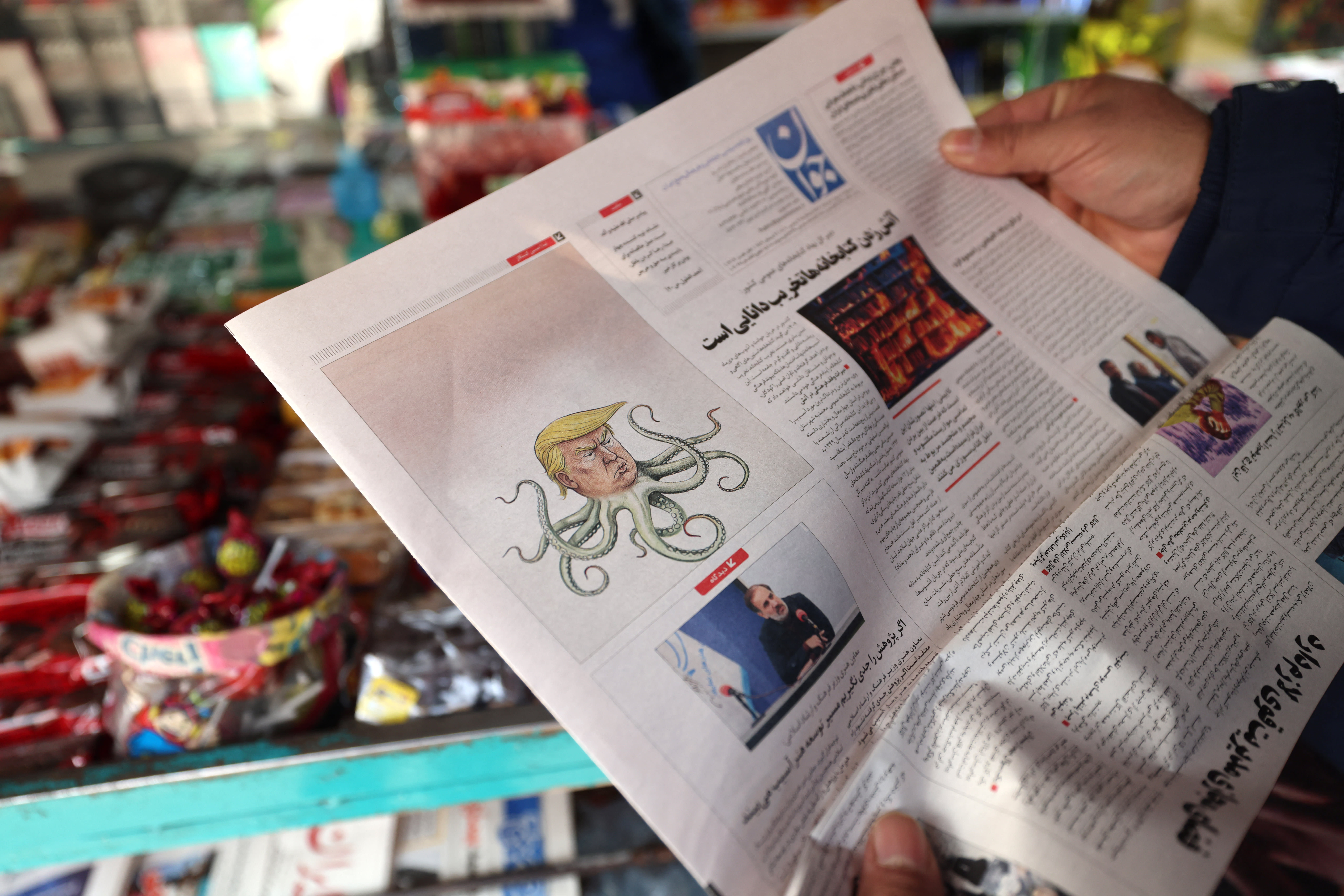 A man reads a newspaper at a kiosk in Tehran on January 27, 2026.  (photo credit: ATTA KENARE / AFP via Getty Images)