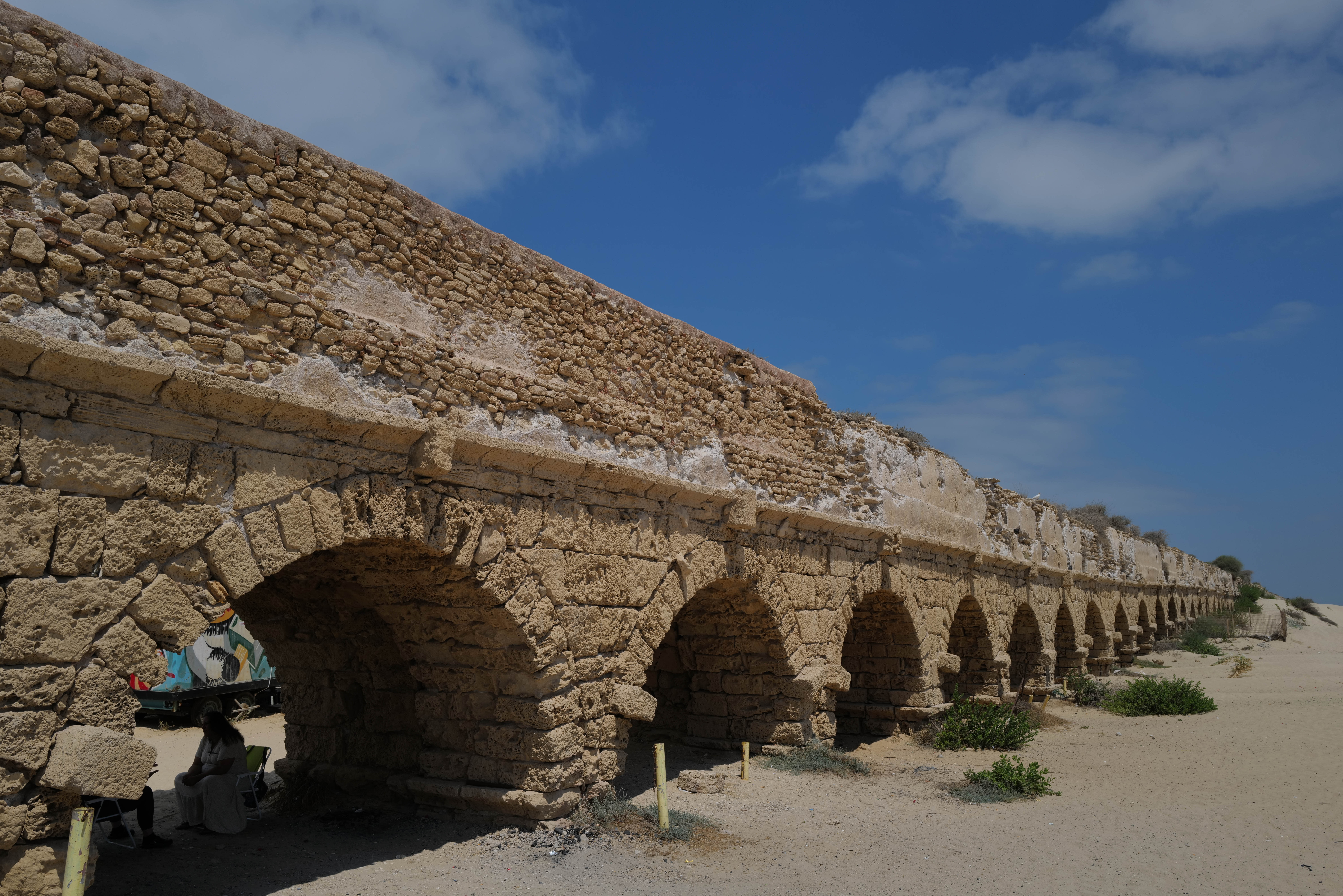 Israelis and tourists enjoy the beach near the 2,000-year-old Caesarea aqueduct, in Caesarea on August 21, 2023. (photo credit: MICHAEL GILADI/FLASH90)