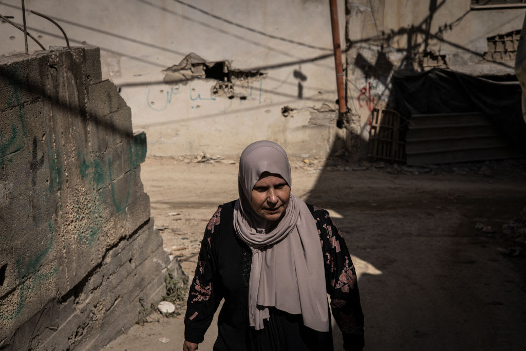 A PALESTINIAN woman walks past damaged houses in Jenin refugee camp on October 9, 2024, in the West Bank. (photo credit: JOHN WESSELS/AFP via Getty Images)