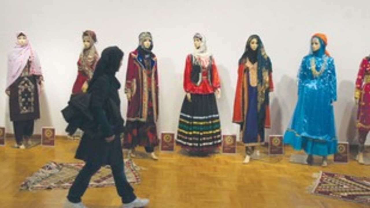 Iranian student walks past mannequins