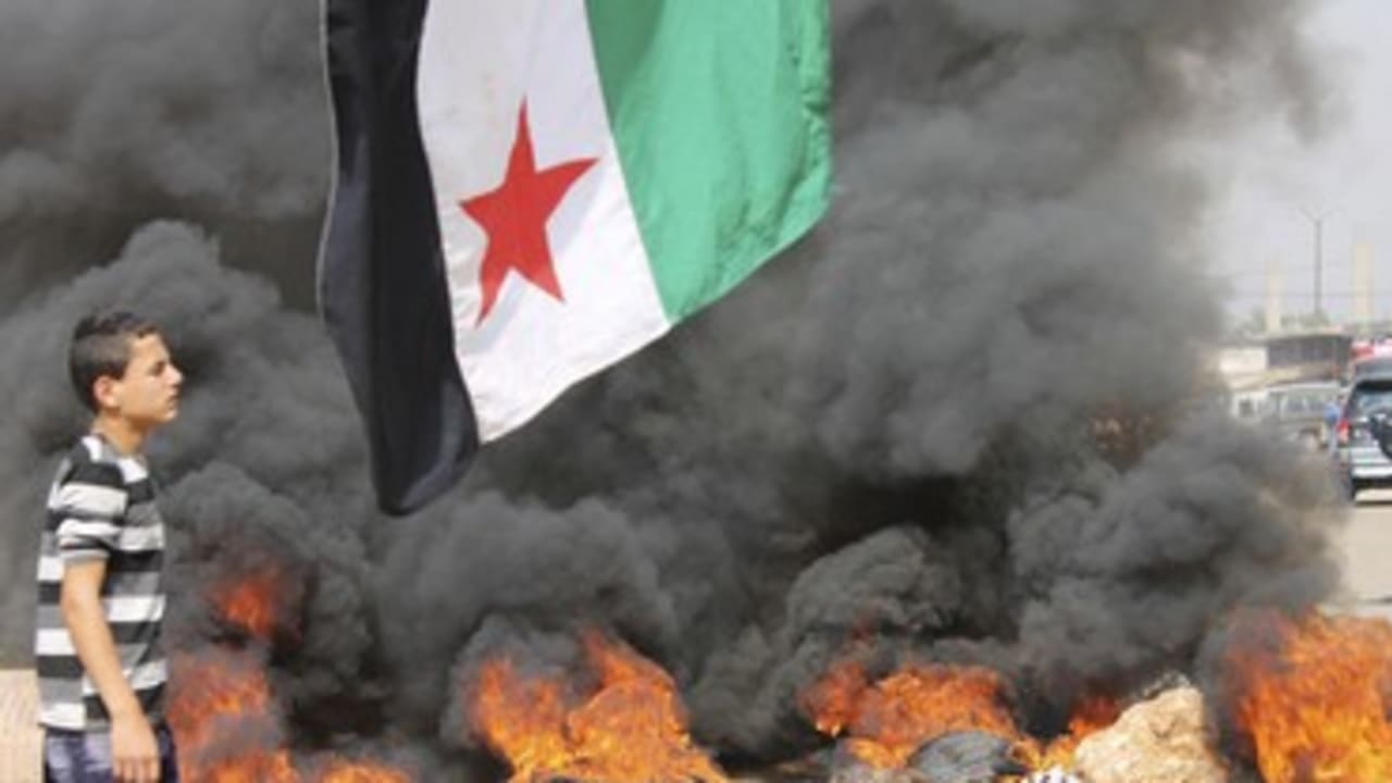 Boy walks past burning tires in Beriut protest 370