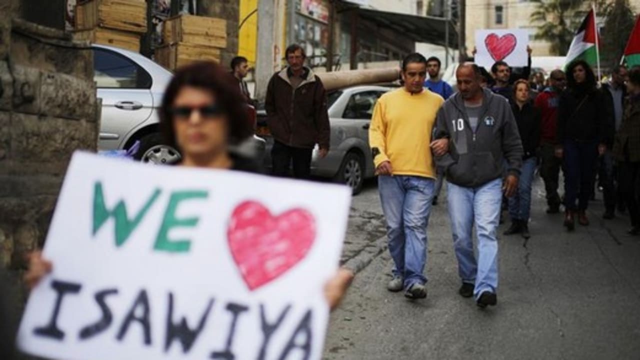 Israeli and Palestinian left-wing activists hold placards during a protest to show solidarity with Palestinians in the East Jerusalem neighbourhood of Issawiya January 4, 2013