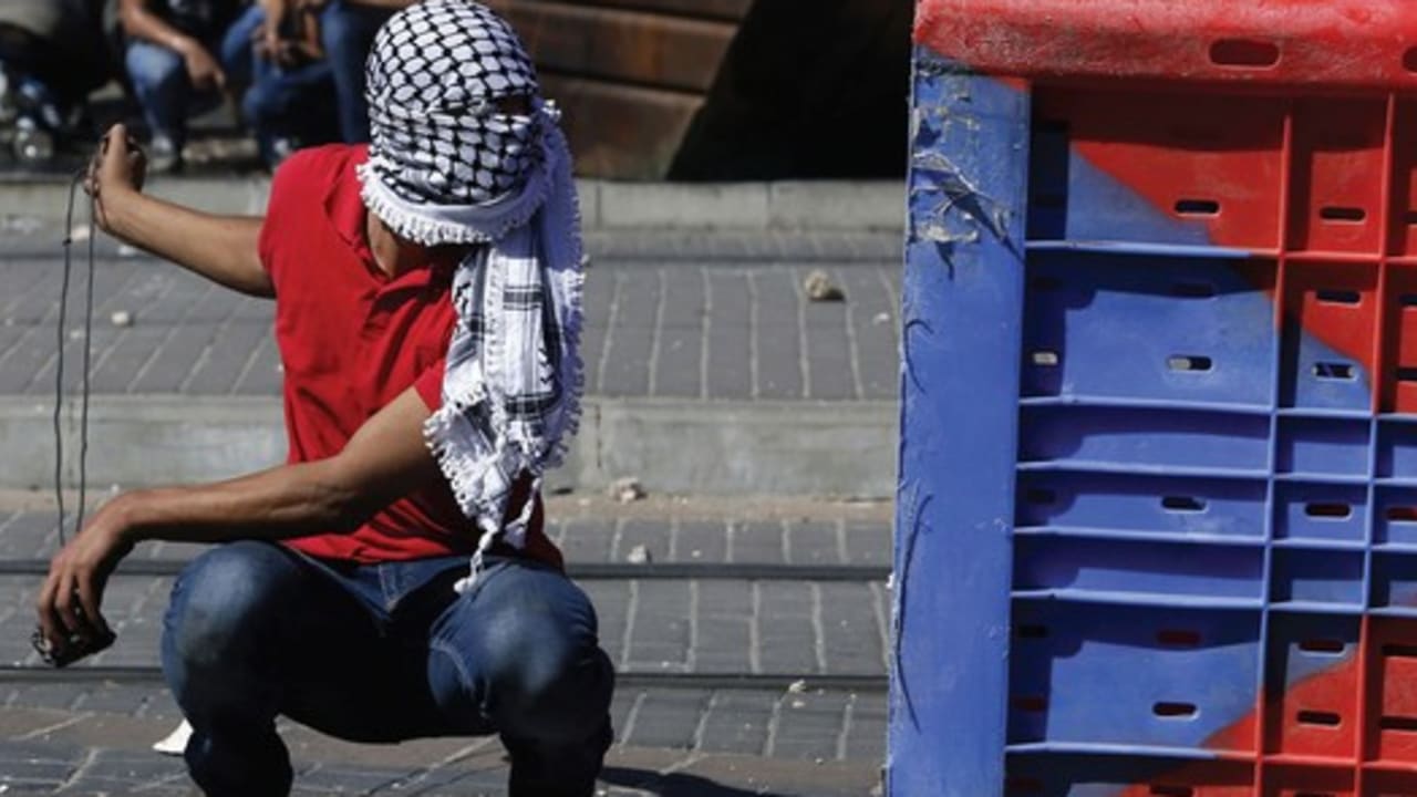 A Palestinian rioter clashes with police in East Jerusalem, July 2, after rumors spread that a missing Palestinian youth had been killed by Israelis avenging the deaths of three abducted Jewish teens