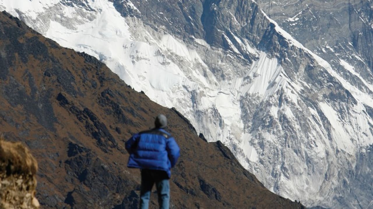 A TOURIST looks at a view of Mount Everest from the hills of Syangboche in Nepal