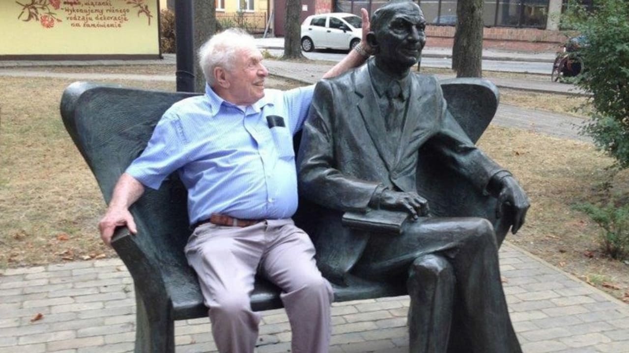 Israel Zamir poses with a sculpture of his father in Bilgoray, Poland.