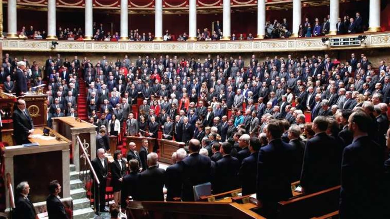 French officials observe a minute of silence during a session at the National Assembly in Paris in honor of the victims of last week’s attacks
