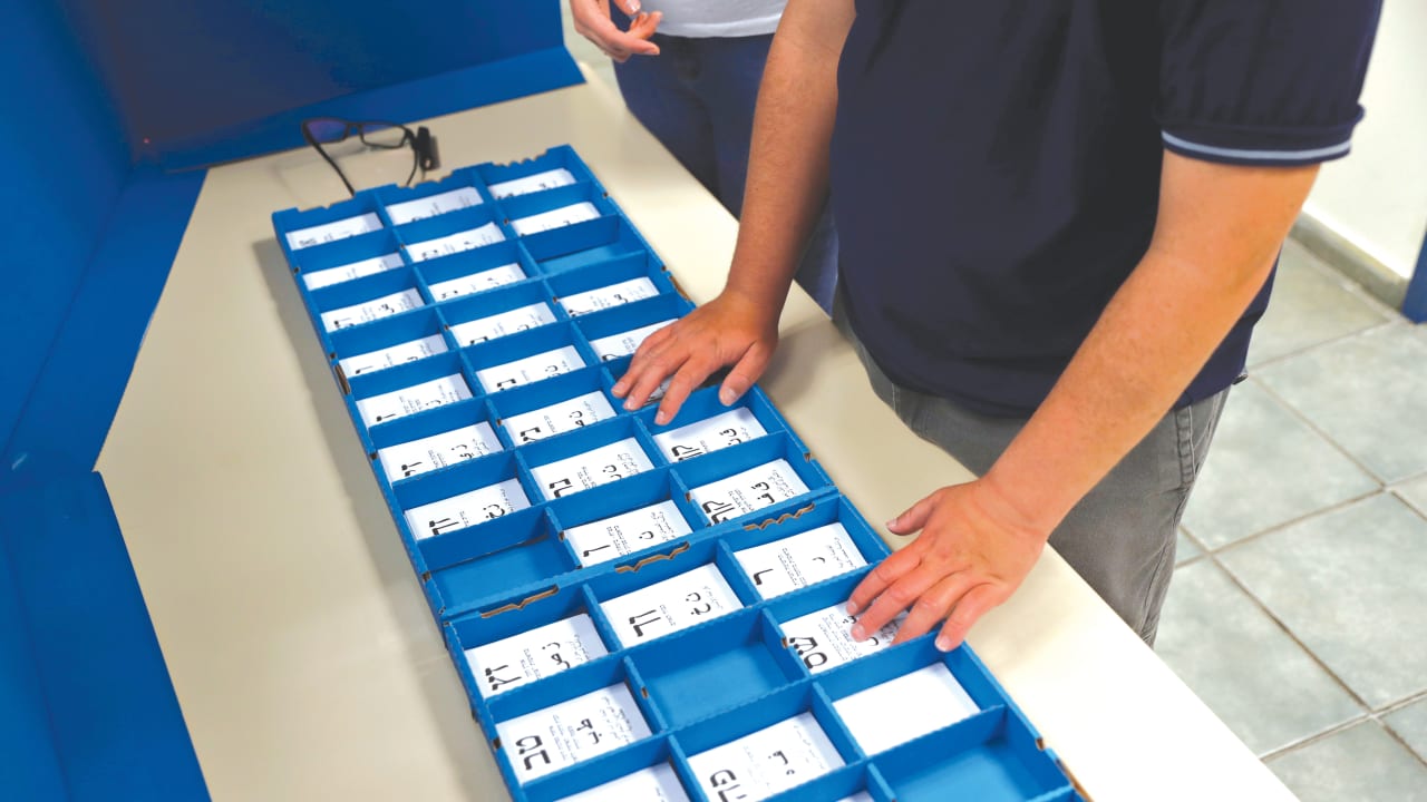 A blind man trains to vote with OrCam, a device that offers aid for the visually impaired 