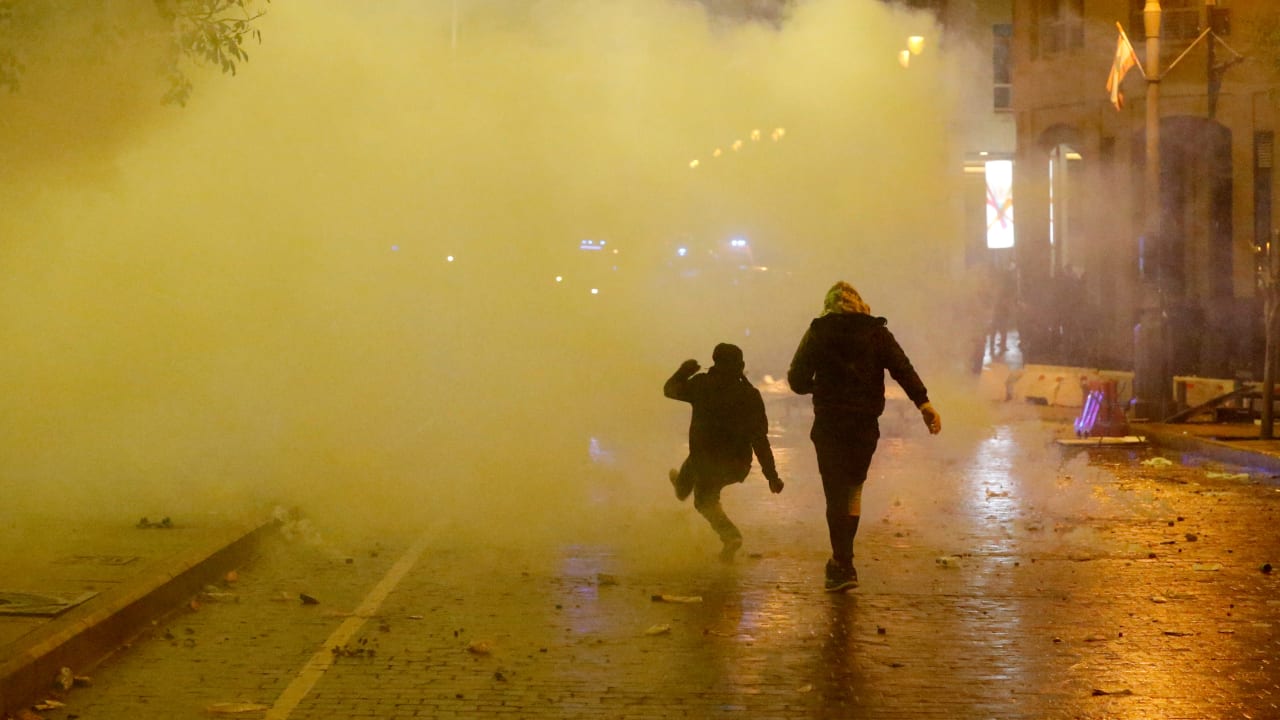 Smoke rises as a demonstrator walks during a protest against a ruling elite accused of steering Lebanon towards economic crisis in Beirut, Lebanon January 19, 2020.