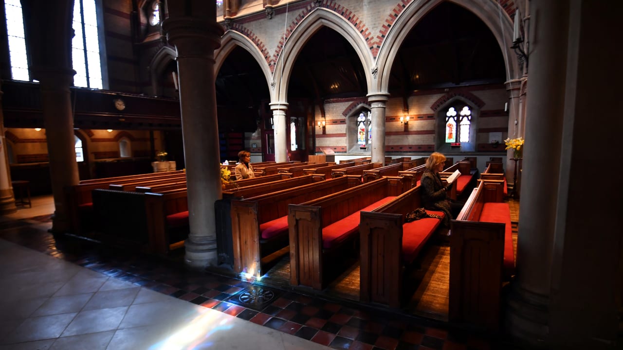 Worshippers pray as their vicar delivers a service to then faithful at home via a live stream over the internet and to a small congregation at the Saint Simon Zelotes Church, as the number of coronavirus disease (COVID-19) cases grow around the world, in London, Britain March 22, 2020