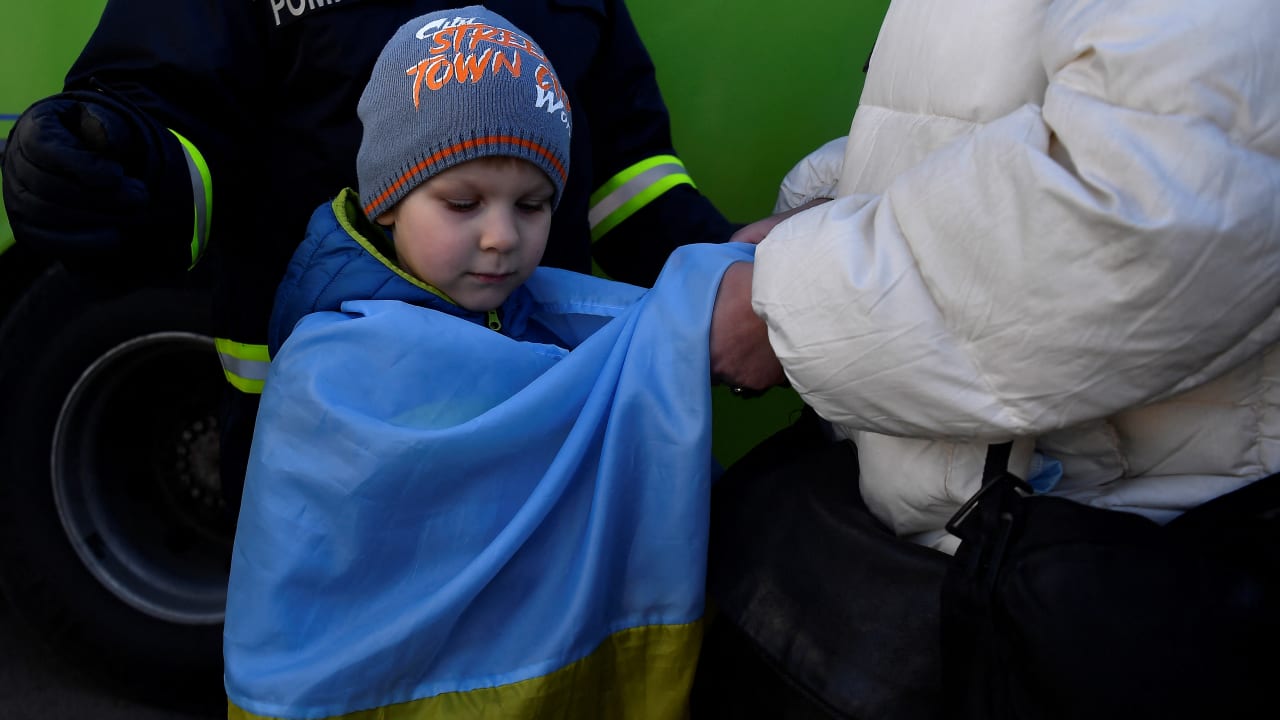  Ivan Iustushenko, 5, is wrapped in a Ukrainian flag by his grandmother after fleeing from Mariupol in Ukraine to Romania, following Russia's invasion of Ukraine, at the border crossing in Siret, Romania, March 22, 2022.