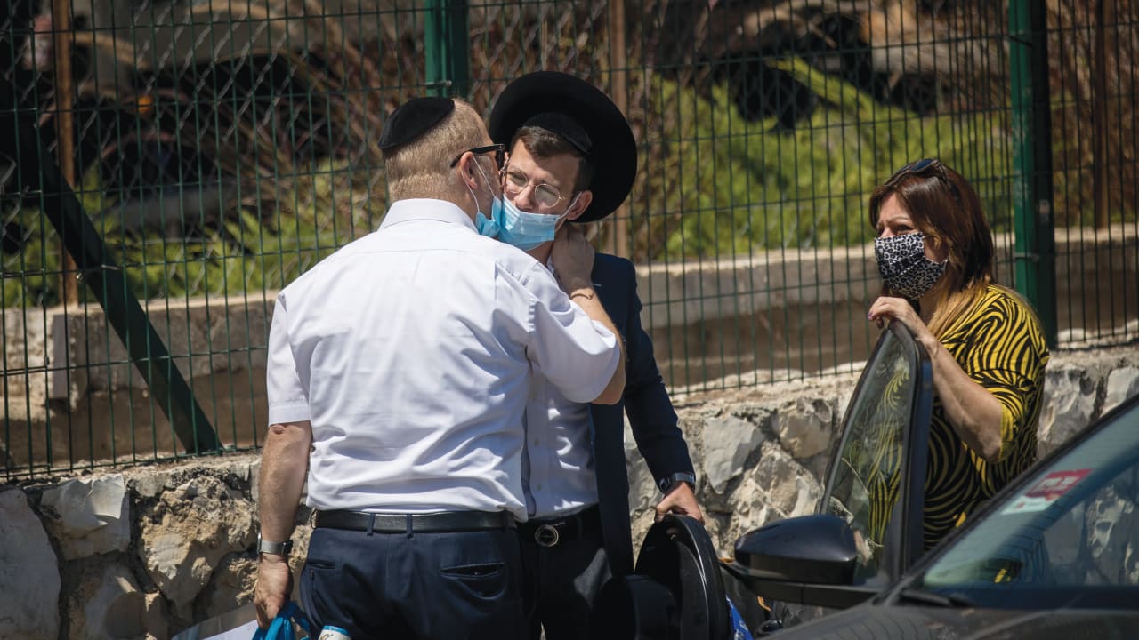  A FATHER kisses his son goodbye outside Hebron Yeshiva, Jerusalem.