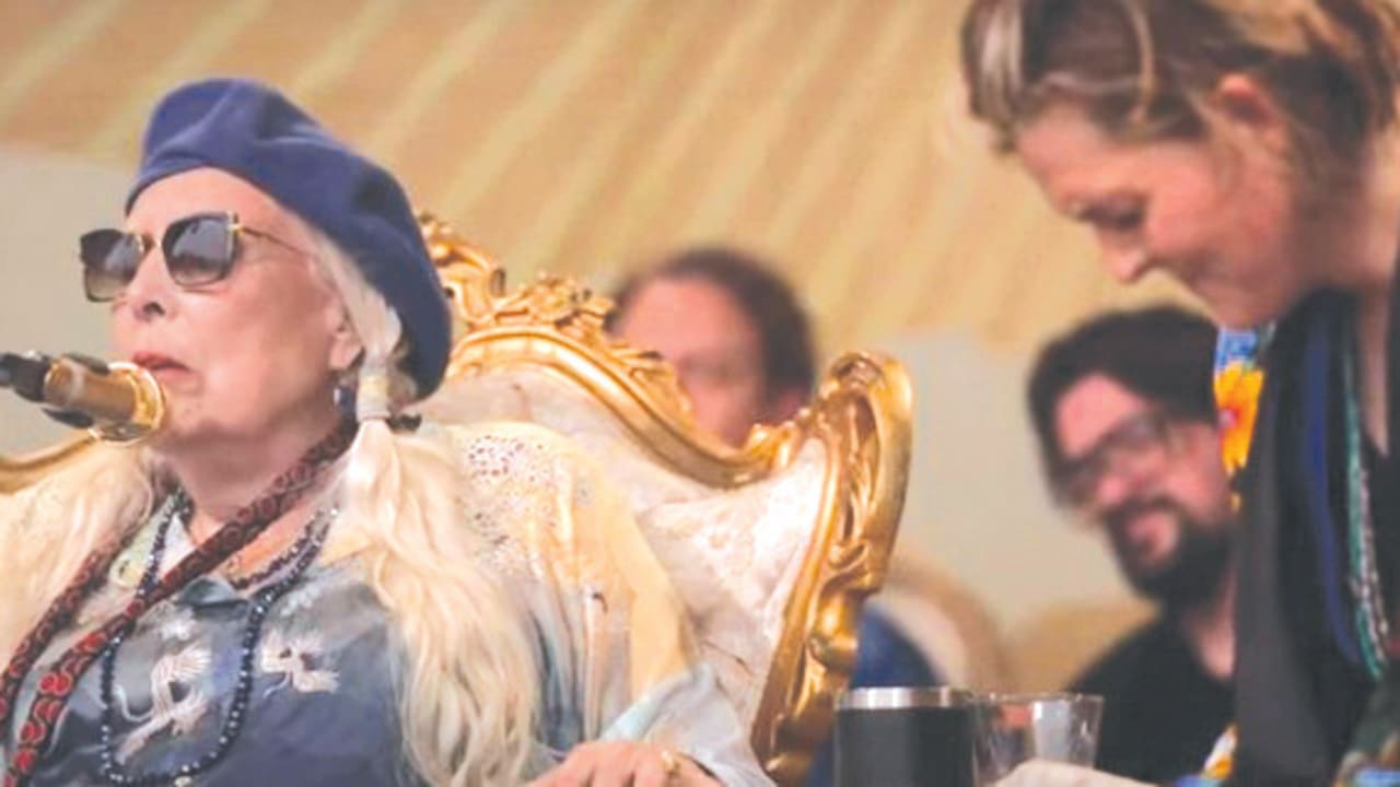  JONI MITCHELL sings at the Newport Folk Festival on Sunday , as Brandi Carlile appears to choke up.