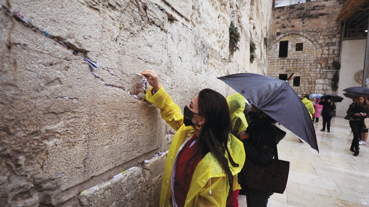  A MISS Universe contestant places a note in the Western Wall last year. The book describes how Jewish outreach activists often approach unaffiliated persons during visits to the site. 