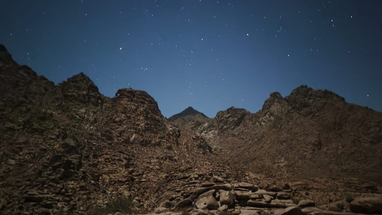  Stars bursting above the triangular peak of the mountain that may be Mount Sinai in the middle of the night, in Saudi Arabia.