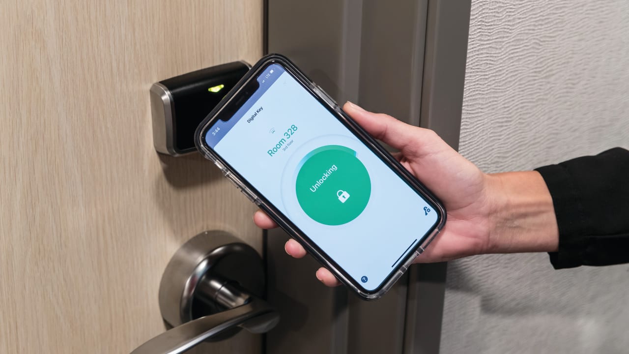  A SMARTPHONE OPENS a hotel guest room door.