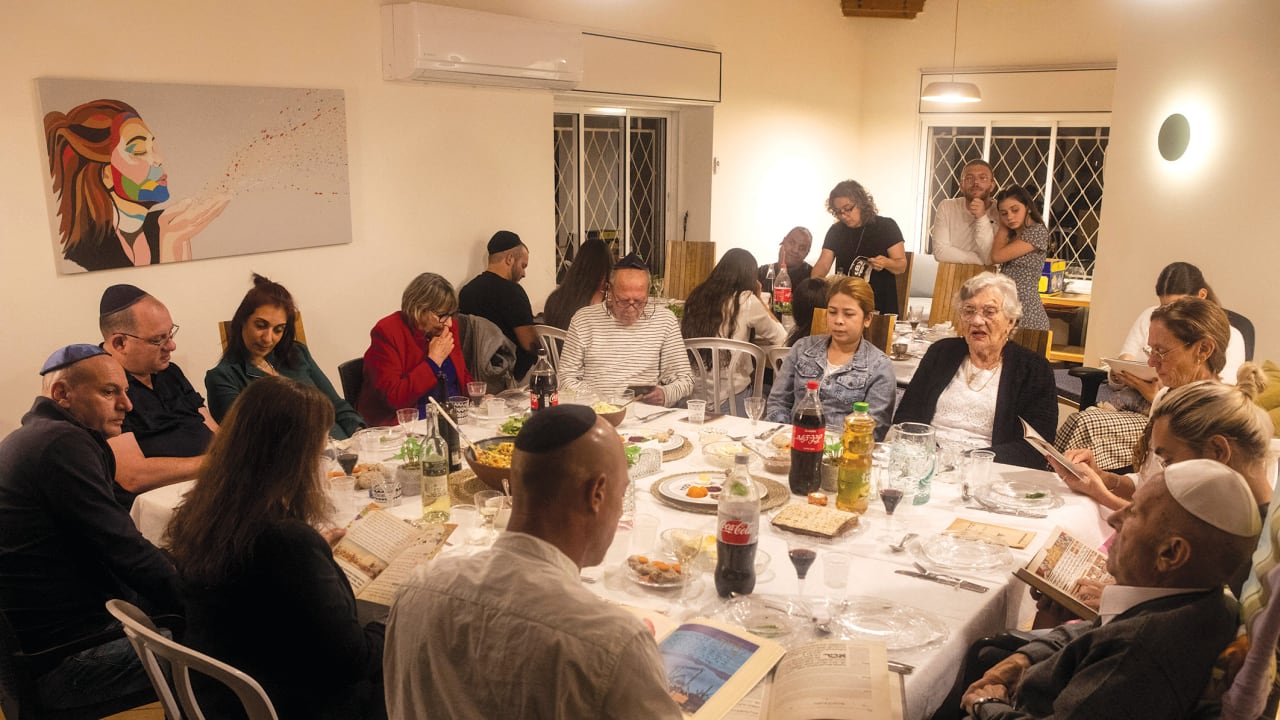   A family sit together for the Passover Seder in Ramat Gan, in 2021