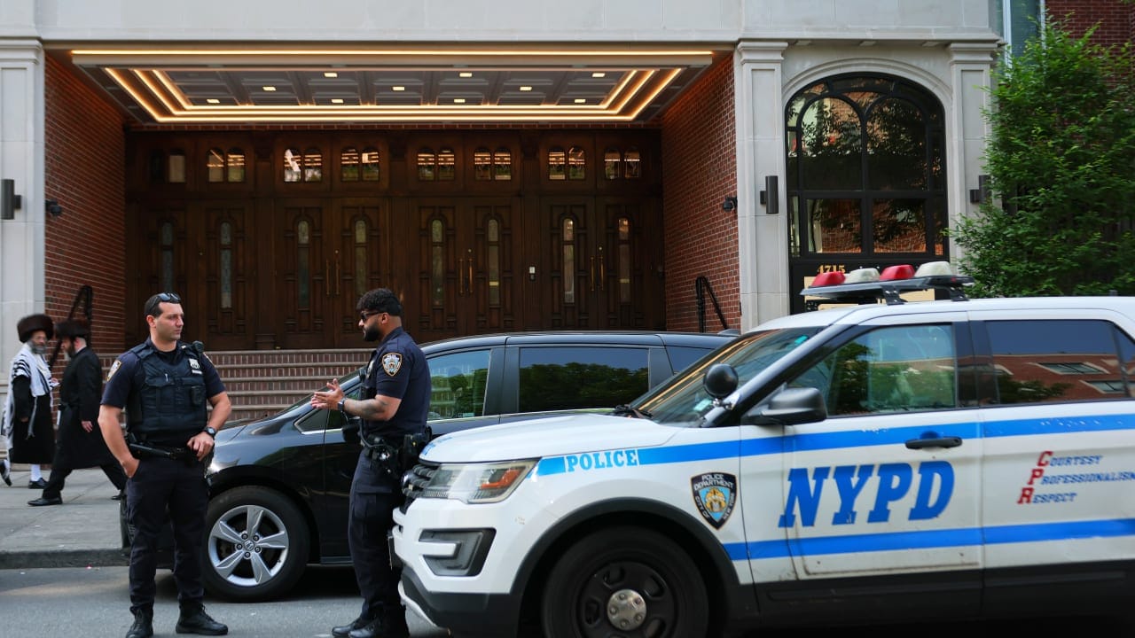 Members of the Orthodox Jewish community walk past NYPD officers as they stand guard outside of Congregation Shaarei Zion of Bobov on June 02, 2025 in the Borough Park neighborhood of the Brooklyn borough in New York City (Illustrative).  