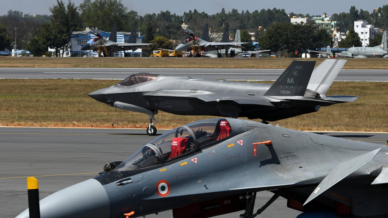 A F-35 fighter jet moves past Indian Air Force's Sukhoi Su-30MKI fighter jet parked on tarmac during the "Aero India 2025" air show at Yelahanka air base in Bengaluru, India.