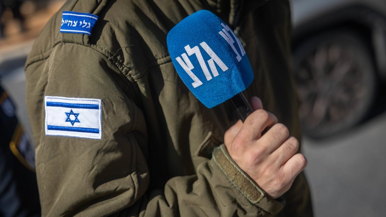 An Israeli soldier holds an Army Radio microphone in Jerusalem, December 22, 2025