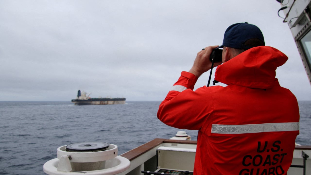 A US Coast Guard official looks through binoculars at the ship Marinera (Ex-Bella 1) in this handout image released January 7, 2026.