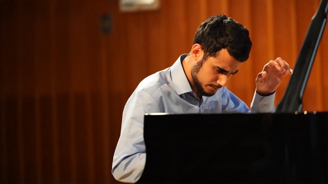 Pianist Ido Shalom takes his seat at the keyboard