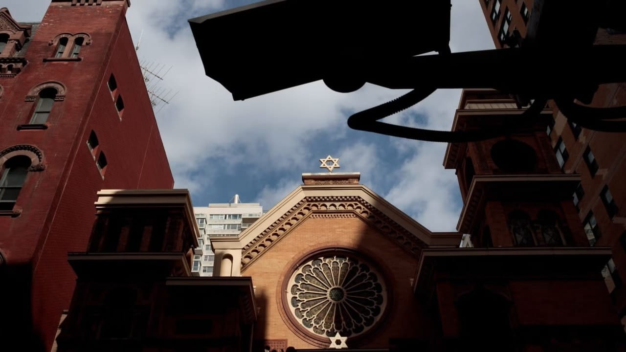 A security camera hangs across the street from the Park East Synagogue, in New York City. Jewish institutions are tightening security amid rising threats.