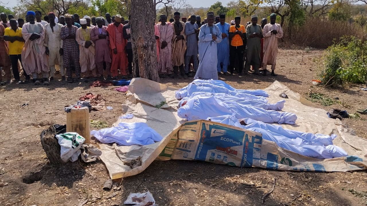 People pray beside the bodies of victims of a terror attack before their burial at Woro community, after an overnight attack by gunmen that killed dozens of residents, in Kaiama Local Government Area of Kwara State, Nigeria, February 4, 2026.