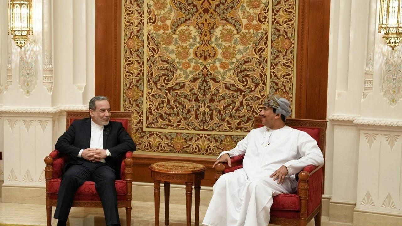 Iranian Foreign Minister Abbas Araghchi (L) talks with an Omani official in Muscat ahead of talks with the US, February 6, 2026.